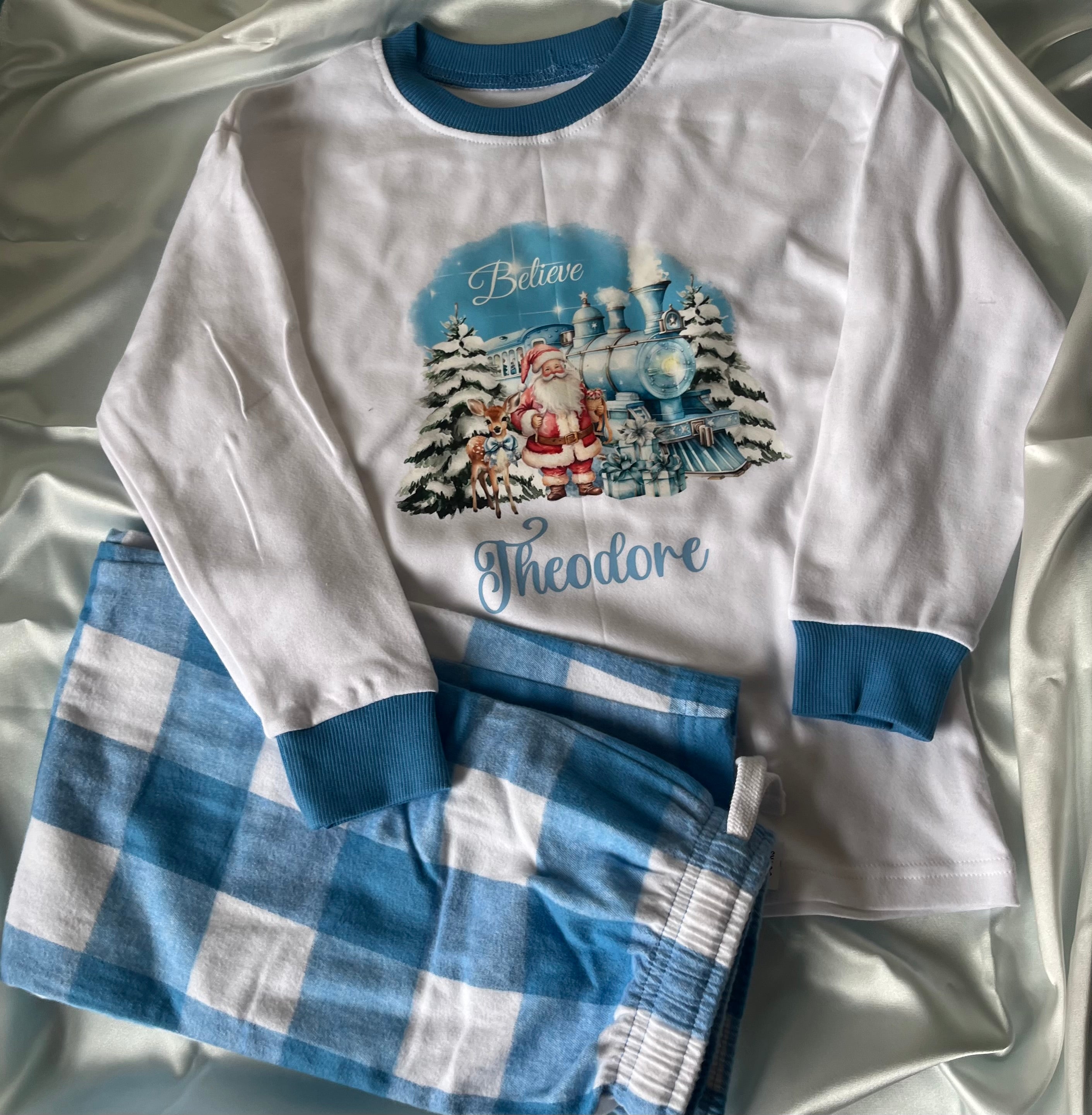 Personalised Christmas Pyjamas in Pink or Blue with Blue or pink Checkered Bottoms and Santa Design