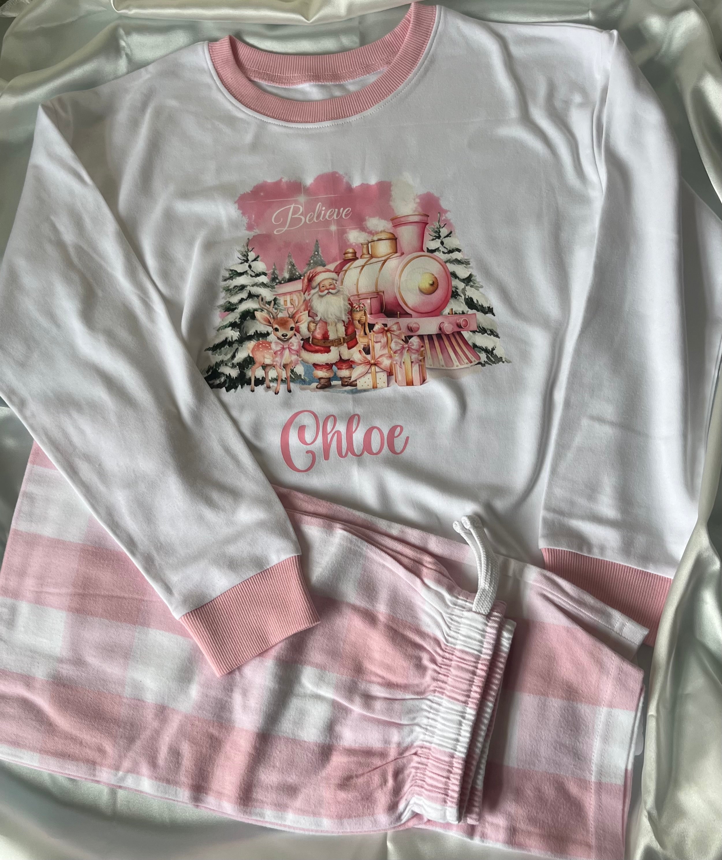 Personalised Christmas Pyjamas in Pink or Blue with Blue or pink Checkered Bottoms and Santa Design